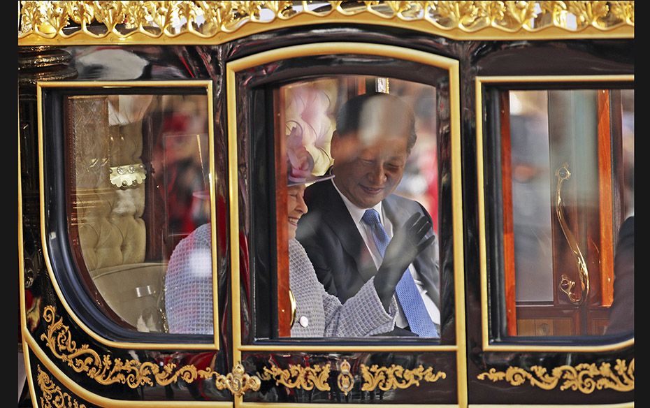 Britain’s Queen Elizabeth and Chinese President Xi Jinping are driven by carriage along The Ma