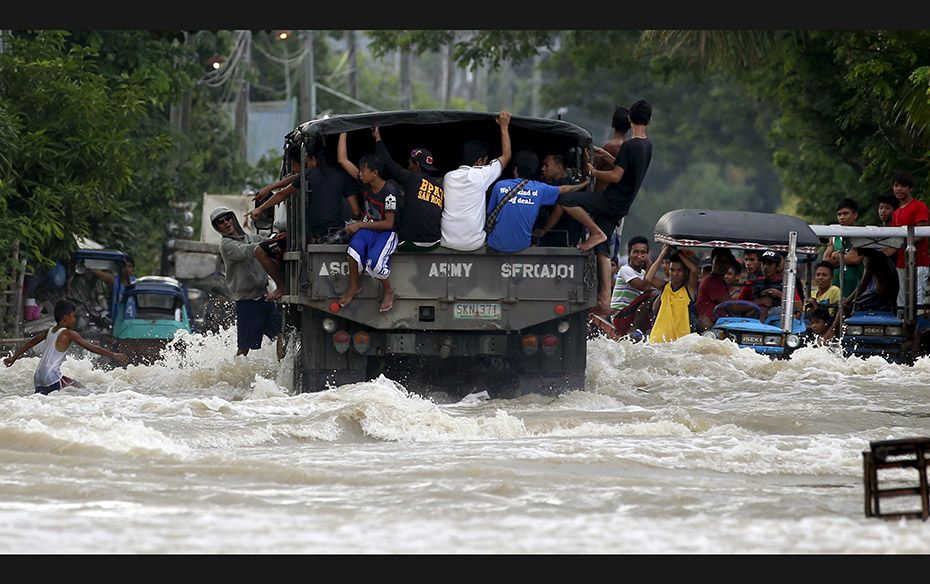 Locals are transported on a military truck along a flooded portion of a highway in Zaragoza, Nueva E