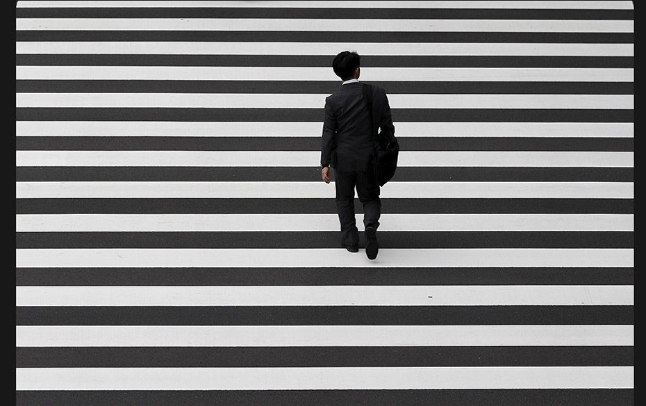 A businessman crosses a road at Tokyo's business district on October 1, 2015. Japanese big manuf