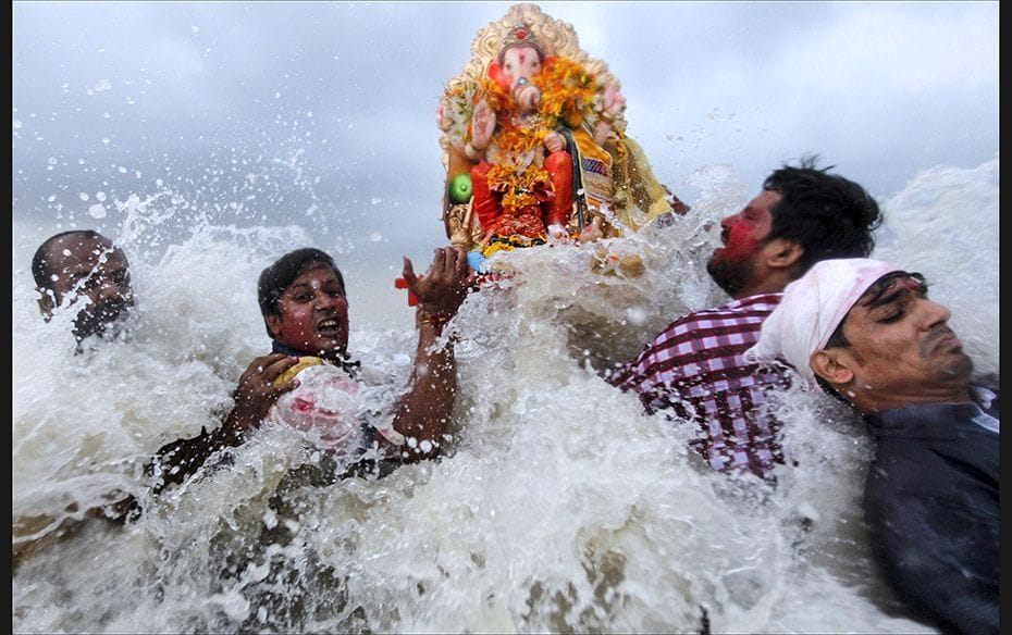 Devotees carry an idol of the Hindu god Ganesh, the deity of prosperity, into the Arabian Sea on the