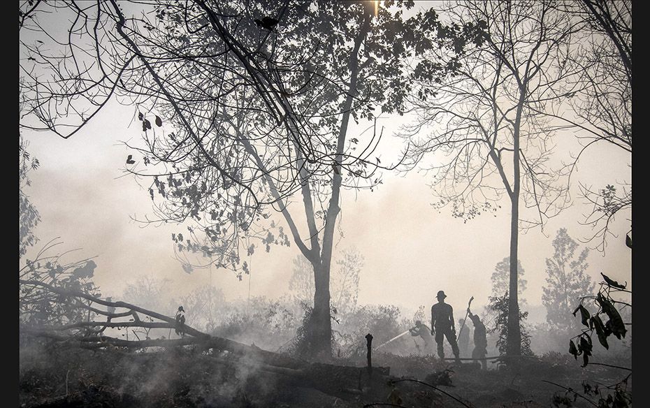 Indonesian police spray water on a peatland fire in Kampar, Riau province on the Indonesian island o