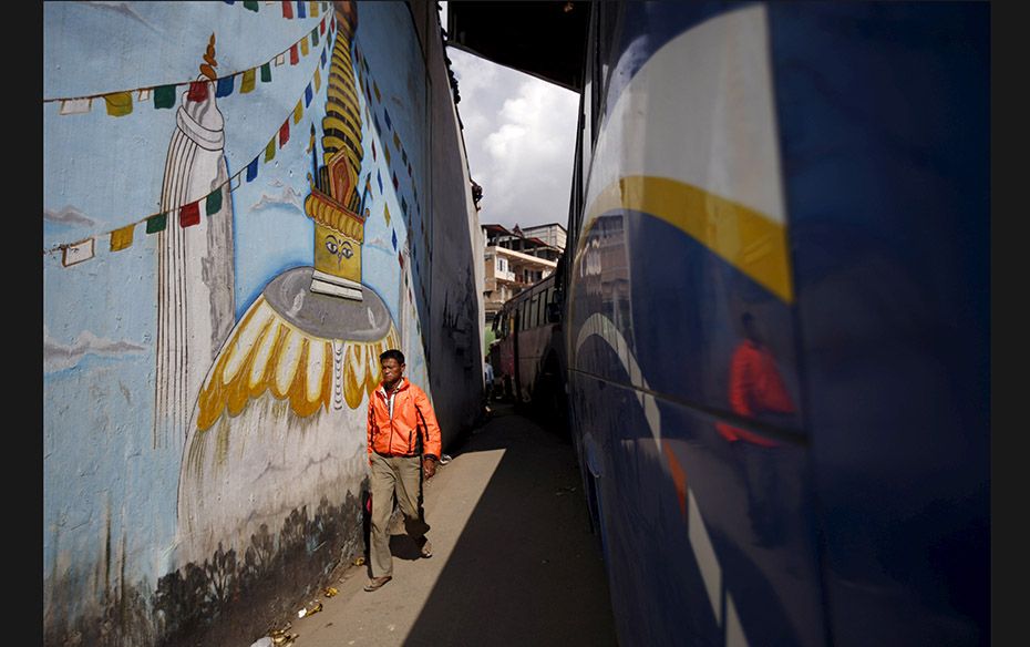 A man walks past long-distance passenger buses queuing for fuel in Kathmandu, Nepal on October 16. T