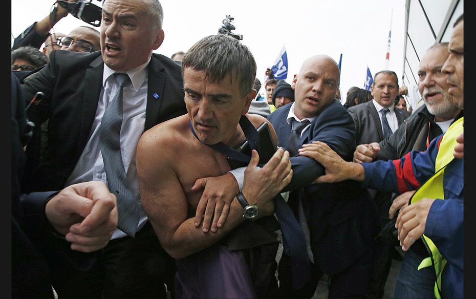 A shirtless Xavier Broseta (2nd Left), executive vice president for human resources and labour relat