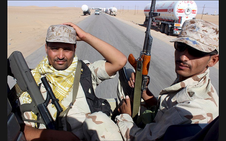 Yemeni soldiers trained by Saudi Arabia drive past empty gas tankers near the Marib oil fields, Yeme