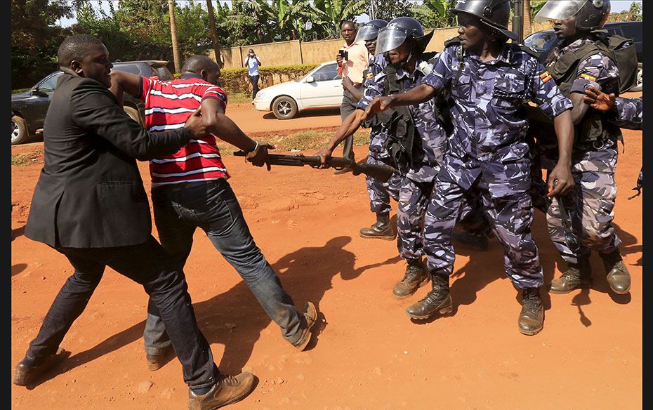 A supporter of Uganda's former Prime Minister Amama Mbabazi wrestles with a policeman in Jinja t