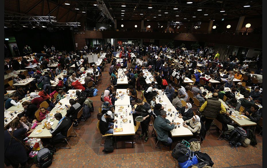 Migrants eat at a reception centre after their arrival at the main railway station in Dortmund, Germ