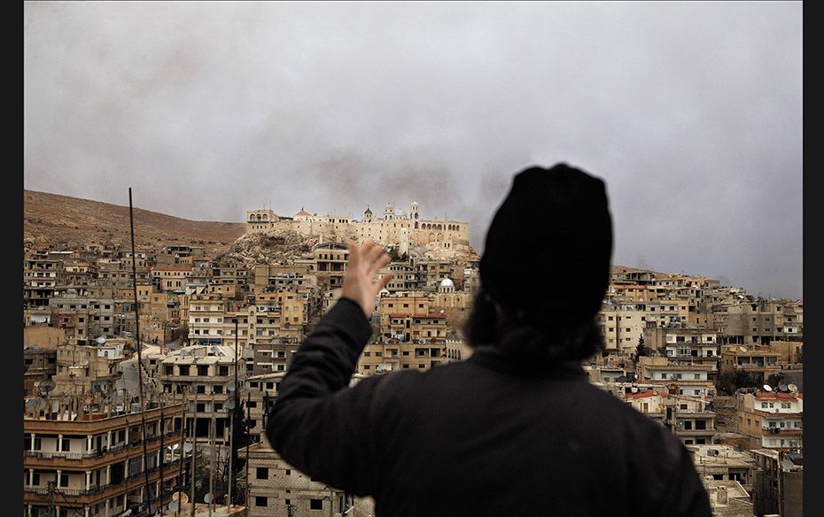 Syria A Greek Orthodox monk from St George’s monastery points at the convent of Our Lady of Sa