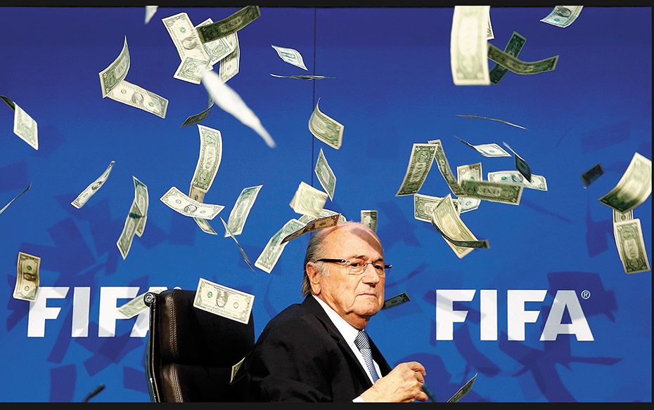 Currency notes are thrown at FIFA President Sepp Blatter as he arrives for a news conference on July