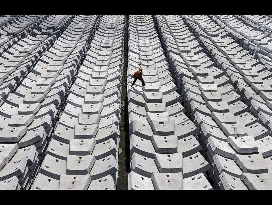 A worker walks over giant pieces of concrete that will be used to make tunnels for the metro railway