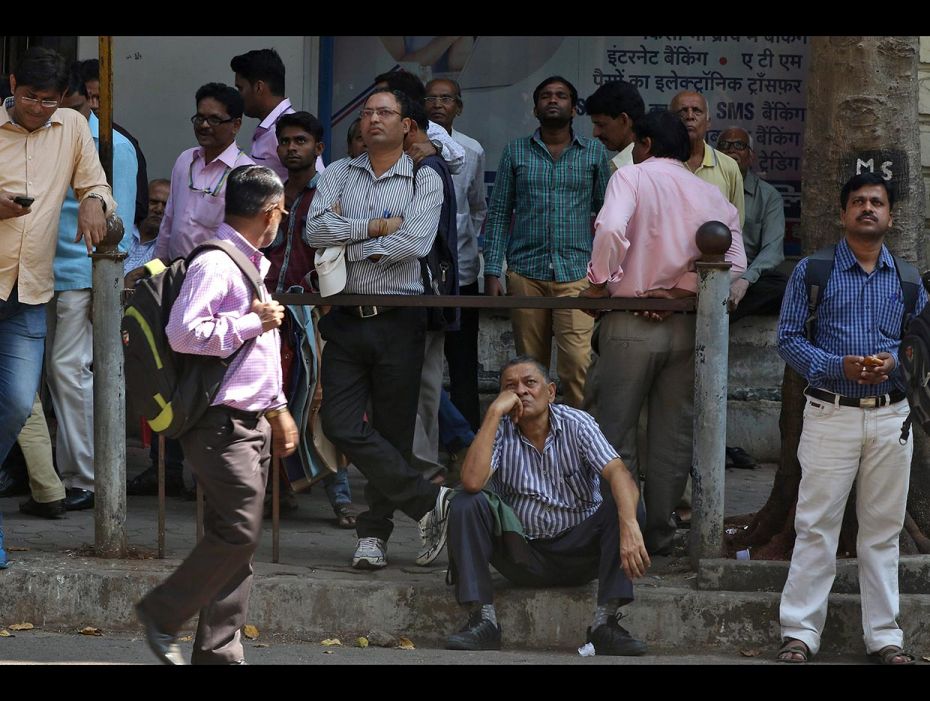 People look at a screen displaying the Sensex on the facade of the BSE building in Mumbai on Februar