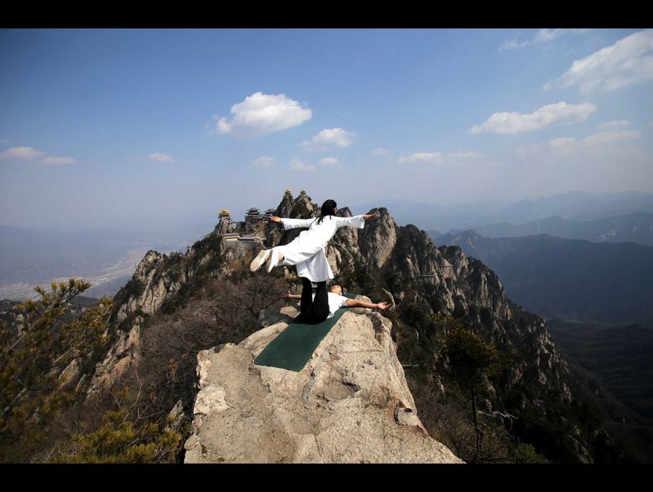 This is no illusion! Chinese yoga fans perform on a 2,000-meter high precipice on Laojun Mountain du