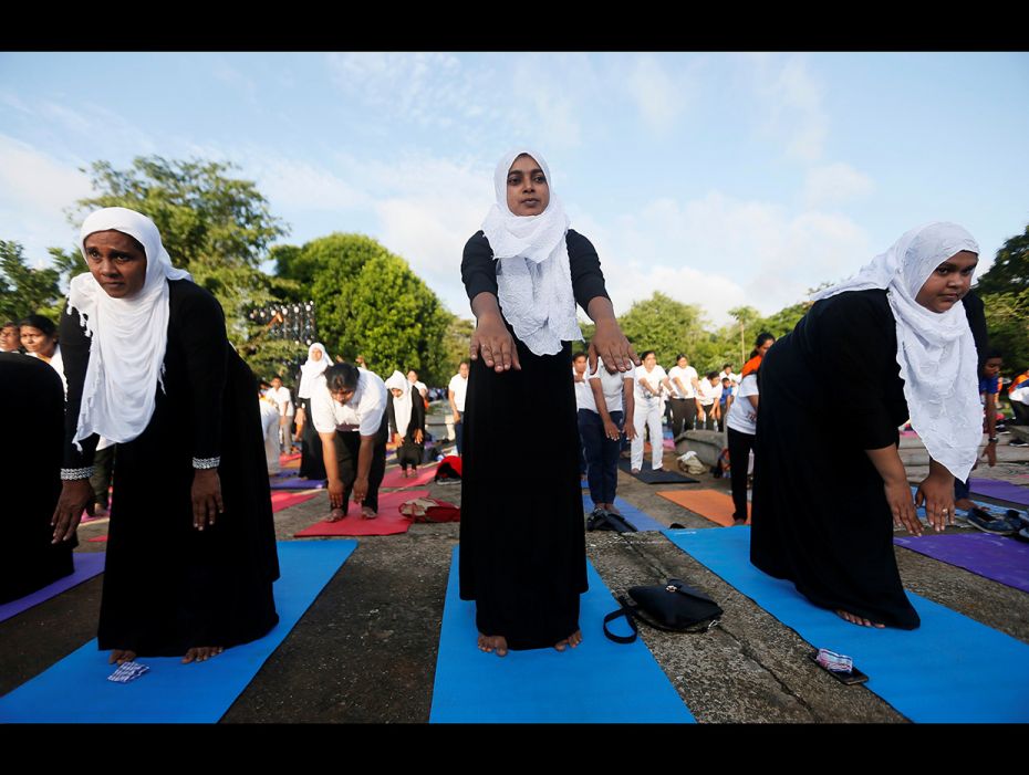 Muslim women perform yoga at an event to mark the International day of Yoga during the holy month of