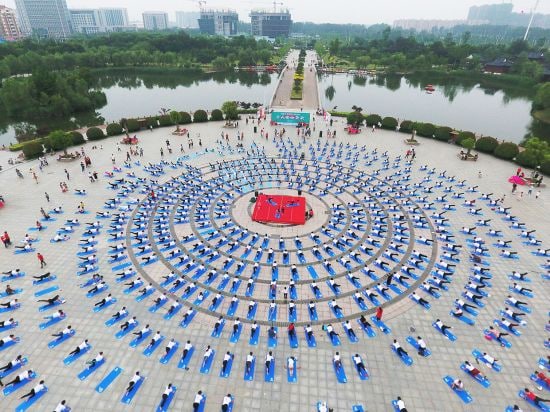 FENGXIAN, CHINA - MAY 27: An aerial view of yoga enthusiasts performing yoga exercises at a park on 