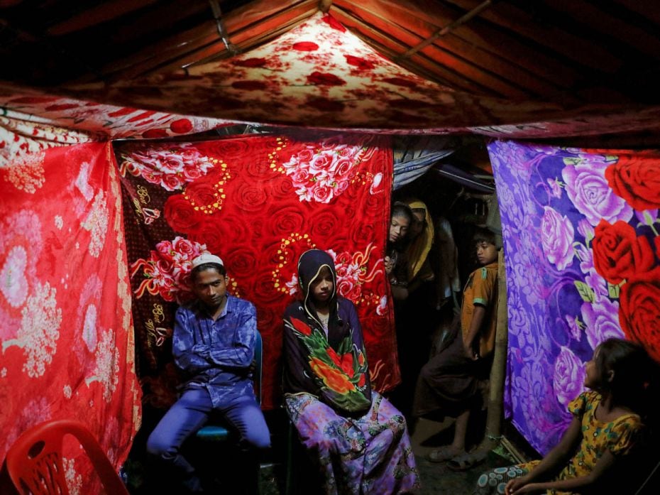 Rohingya refugees Saddam Hussein, 23, and his wife Shofika Begum, 18, pose in a colourful tent decor