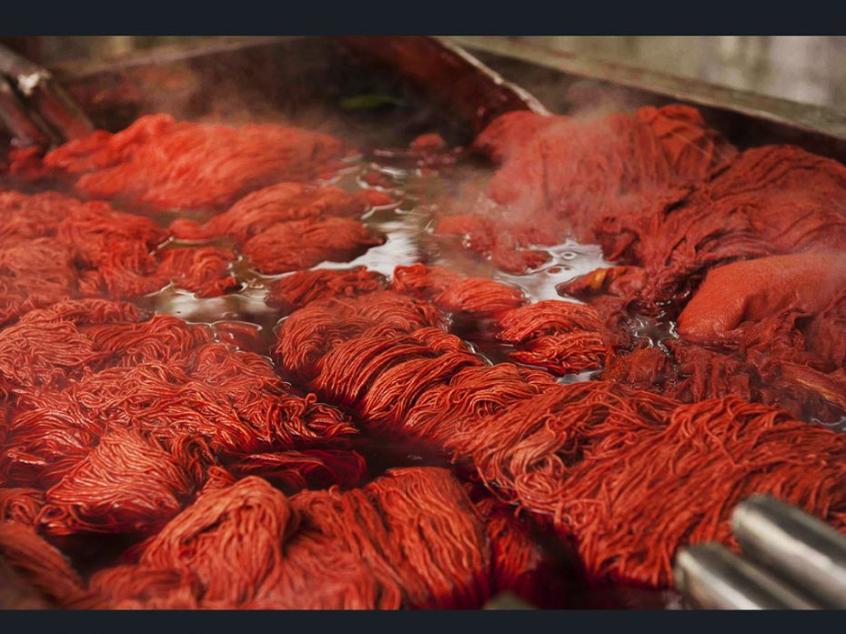 Yarn is soaked in the dye. Depending on the strength of the colour required, it may remain soaked fo