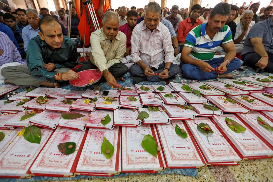 Indian businessmen pray in front of their record-keeping books as a part of a ritual, called "C