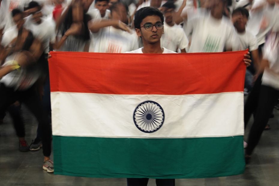 A student holds a national flag during a flash mob at a railway station in Mumbai, India on August 1