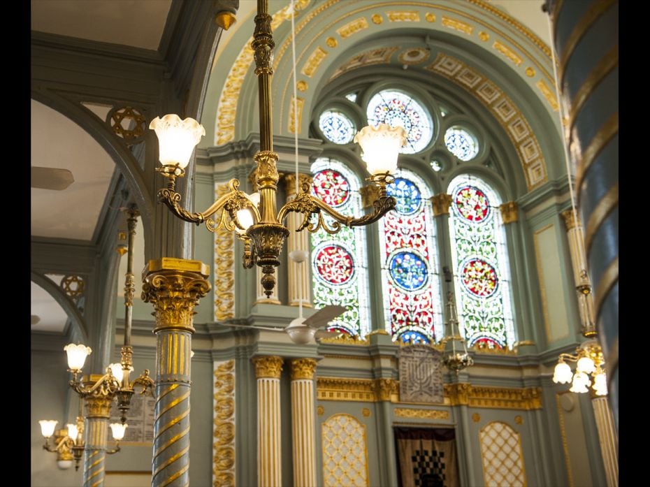 Victorian chandeliers are seen suspended across the synagogue—most of the lighting is original