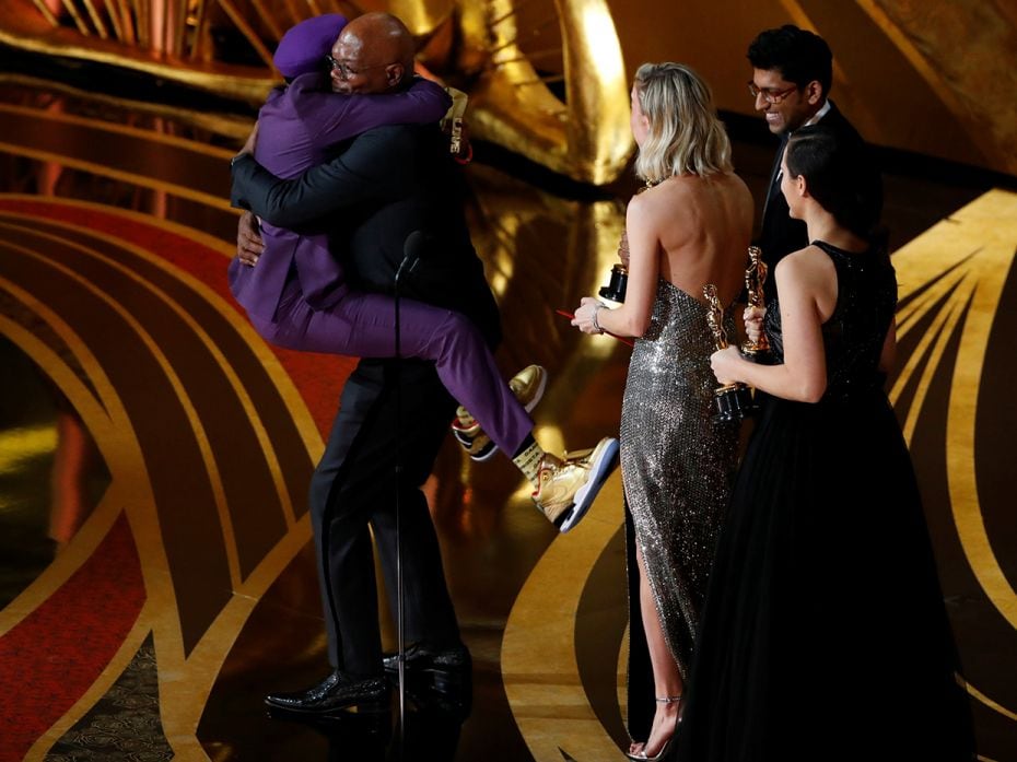 Spike Lee (L) embraces presenter Samuel L. Jackson as he wins the Best Adapted Screenplay award for 