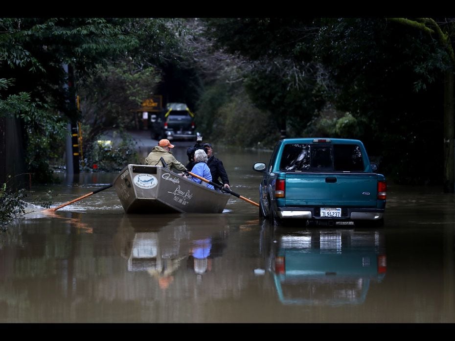 Residents use a boat to navigate floodwaters on February 15, 2019 in Guerneville, California. An atm