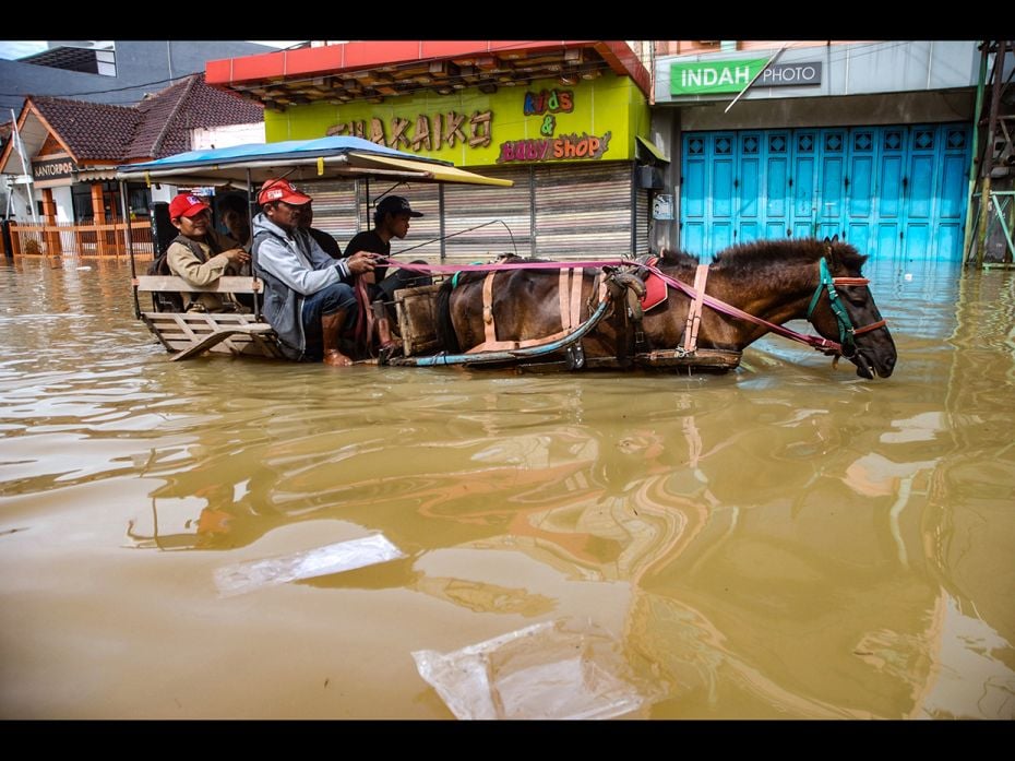 This picture taken on March 7, 2019, shows residents commuting along a flooded road in Dayeuhkolot v