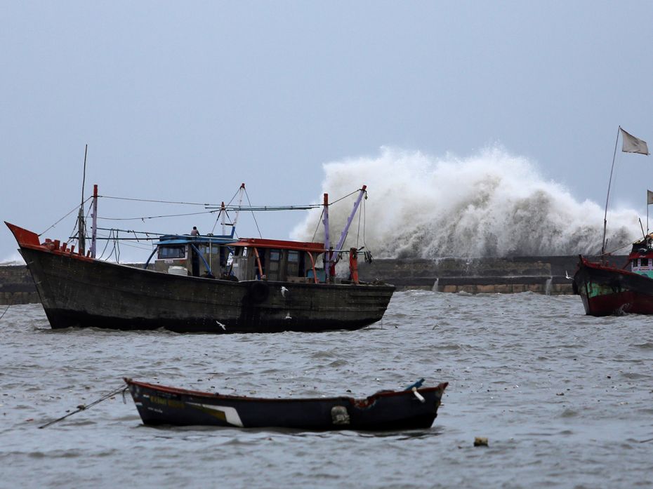 Large waves crash against the jetty at a fishing harbor, ahead of the expected landfall of Cyclone V