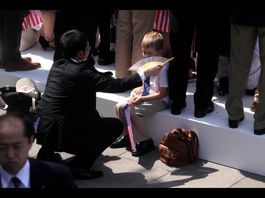 Tokyo, Japan: A child is fanned after standing in the heat to help welcome US President Donald Trump