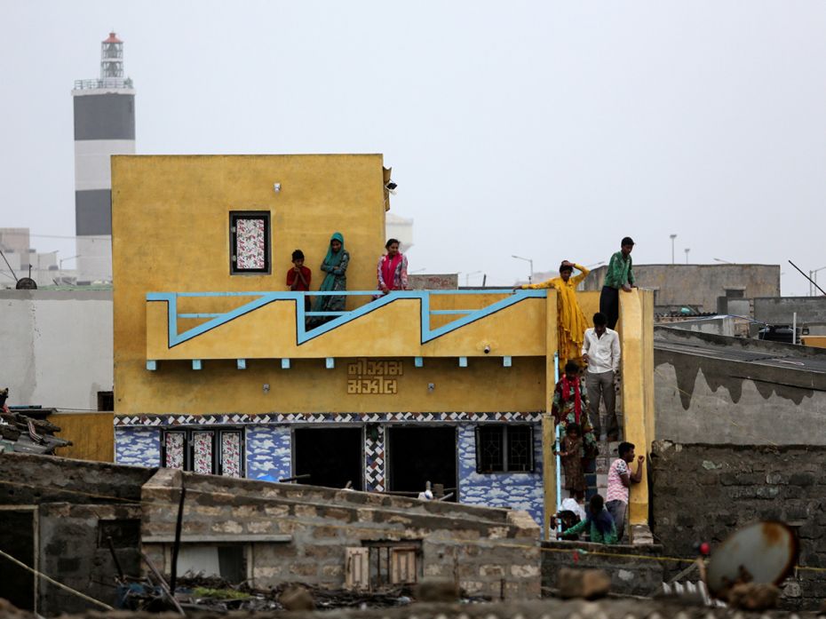 Veraval residents gather to watch helplessly as the tide gets higher, on June 13.