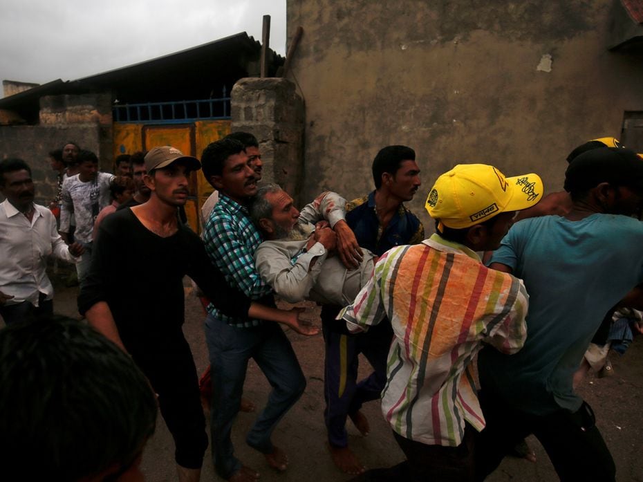 An injured fisherman, who found his boat capsized in the strong current, is carried to a hospital in