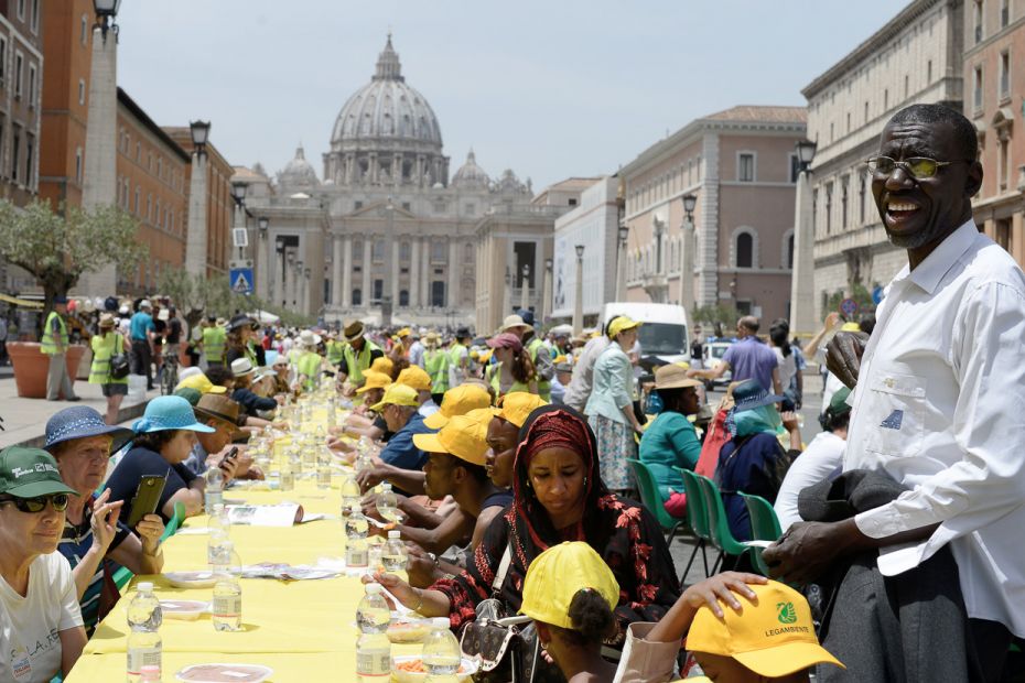 Migrants and locals are invited to partake of a meal on a 270-meter long table in front of St Peter&