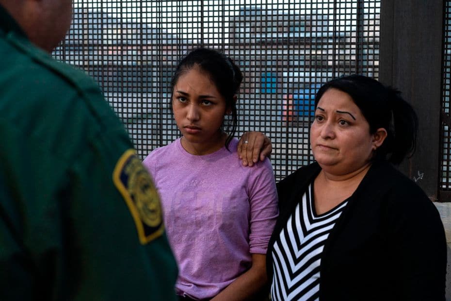 Migrants from Central America wait for a nod from Border Patrol to board a van to a processing cente