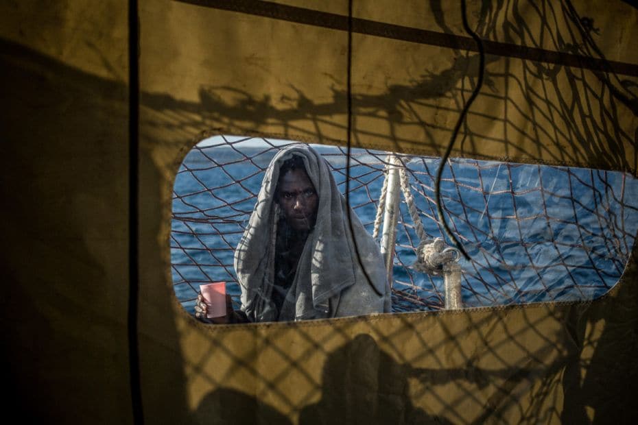 A migrant, part of a group of 47 including minors, watches from the deck of the Dutch-flagged rescue