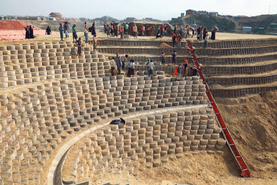 Rohingya refugees construct reinforcements to prevent landslides ahead of the monsoon season at a re