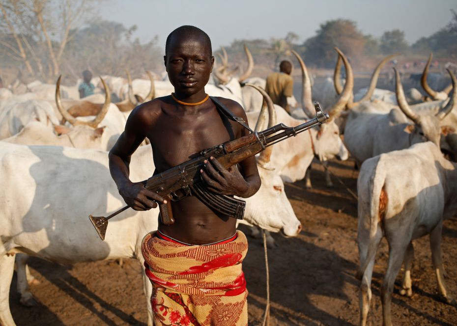 SudanA cattle herder from the Dinka tribe carries a weathered AK-47 rifle to protect his Zebu cows f