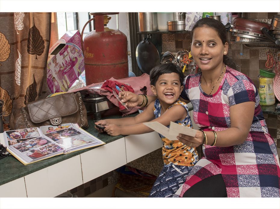 Renu (8) and her mother, Ranjana, go through pictures of her first birthday and naming ceremony. Thi