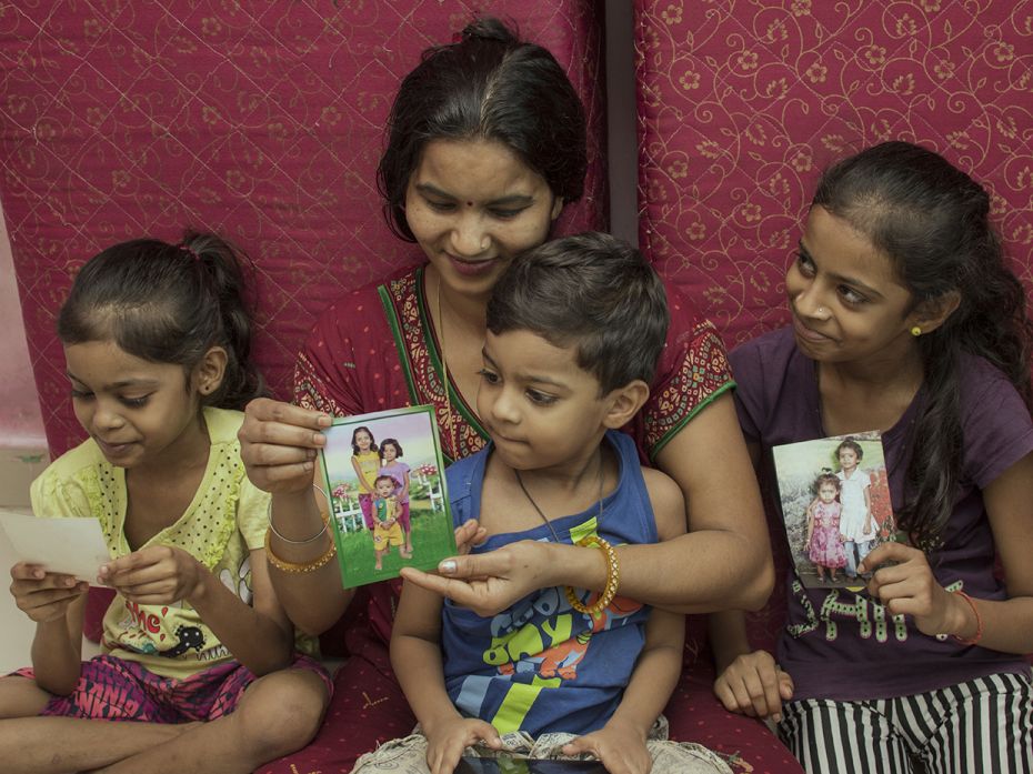 Sandesh (6), Sapna (12) and Sakshi (9) look at their old photographs with their mother Bharti. Since