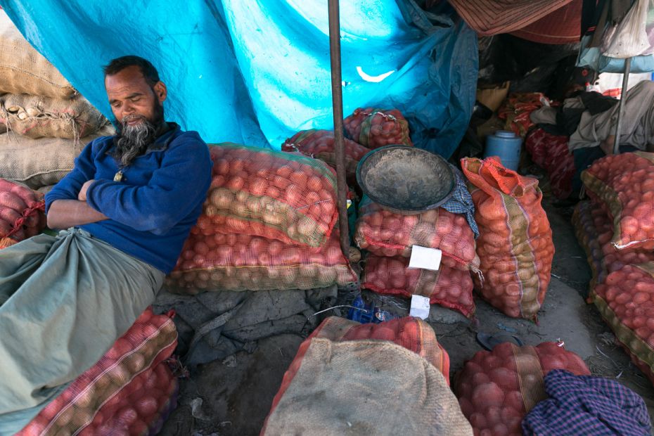 Potato wholesaler Majid Khan points to the rickety buildings around in Ghazipur. The labourers, most