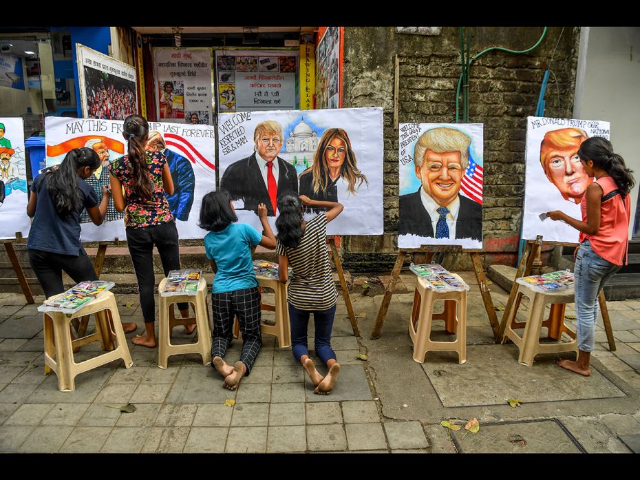 Students painted on canvas faces of US President Donald Trump, his wife Melania (C), and India's Pri