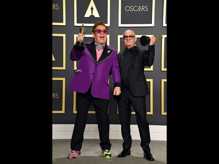 Unlike the usual black tuxedo look for the Oscars, we Elton John is seenmaking a statement of his ow