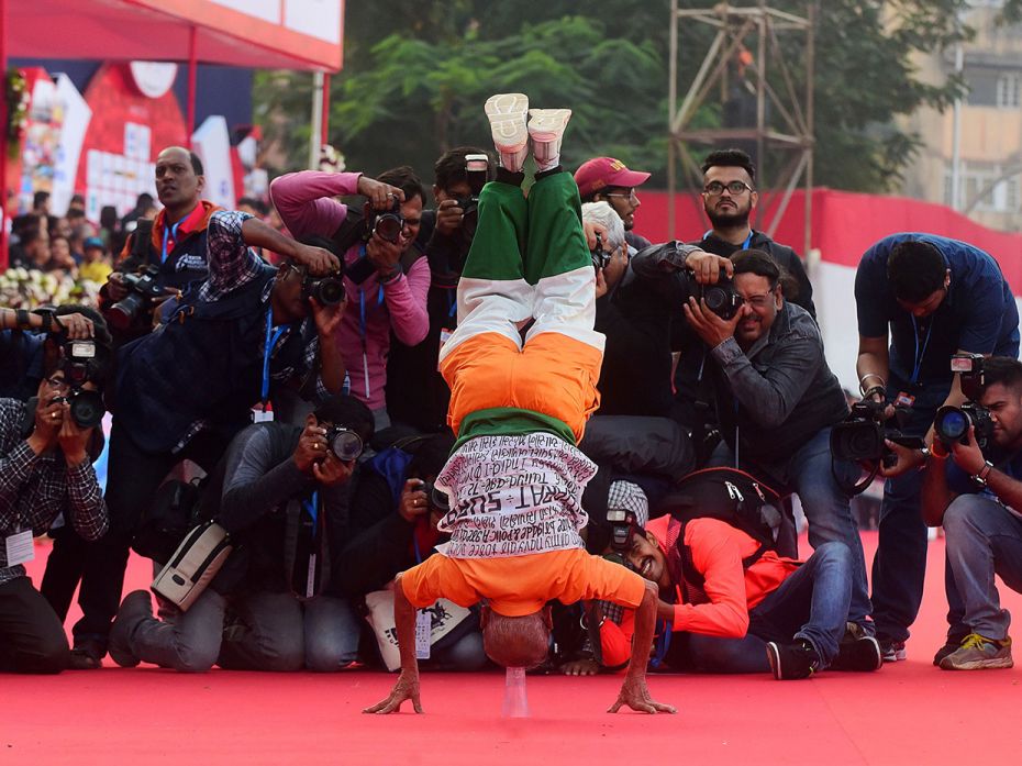 A runner plays to the gallery of photojournalists.