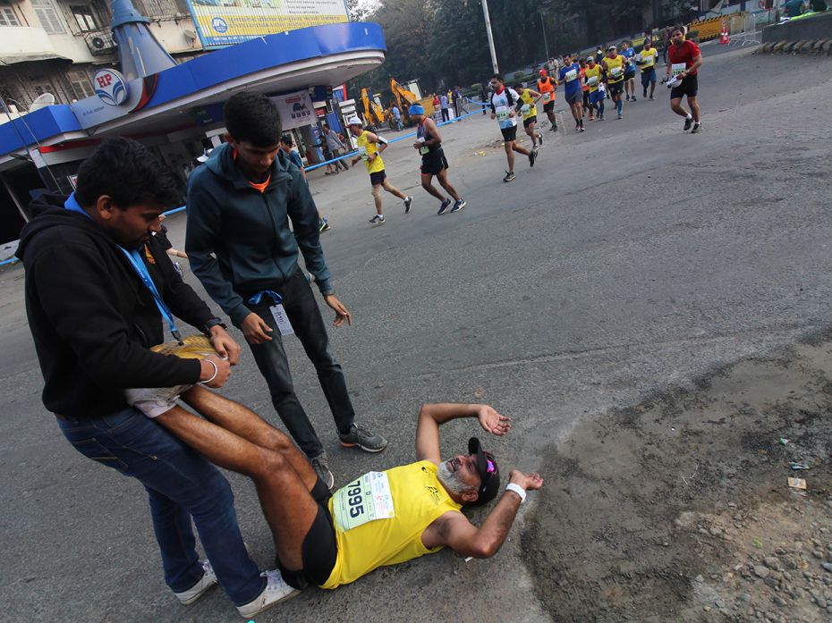 The team helps an injured participant during the Tata Mumbai Marathon. Seven runners suffered heart 