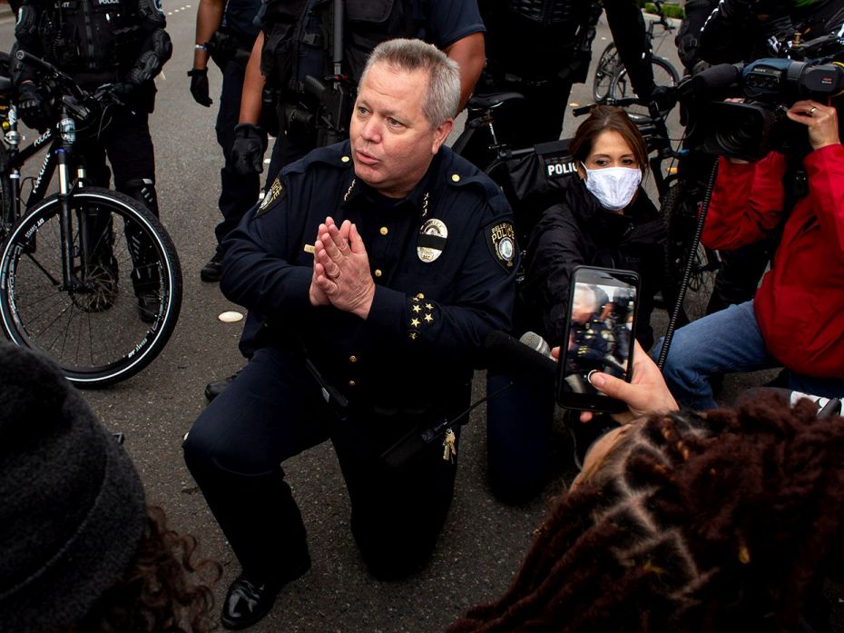 BELLEVUE, WA - MAY 31: Bellevue Police Chief Steve Mylett kneels next to demonstrators during a gath