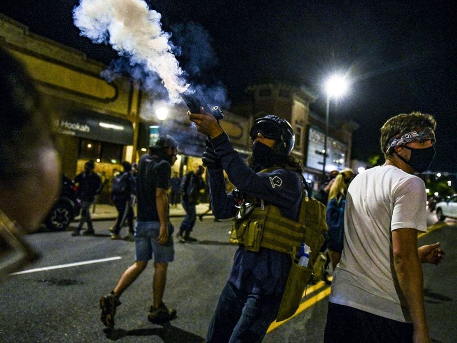 DENVER, CO - MAY 31: A man fires a concussion grenade back at police officers after the officers thr