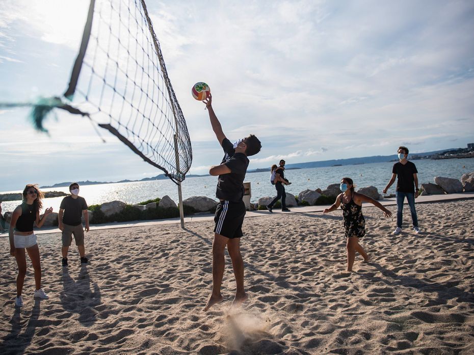 MARSEILLE, FRANCE – JUNE 1: People wearing face masks play volleyball on the Prado beach in Ma