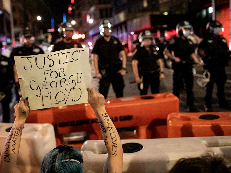 NEW YORK, NEW YORK - MAY 31: A protester holds a sign while facing off with police in Manhattan on M