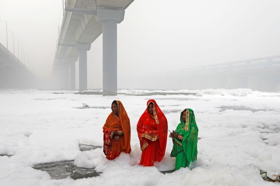 
Women pray on Chhath Puja in the polluted waters of Yamuna river in New Delhi,