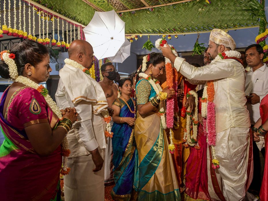 BENGALURU, INDIA – JUNE 3: Family members watch as the bride and groom garland each other duri