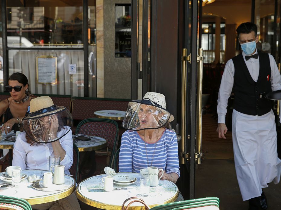 PARIS, FRANCE - JUNE 2: Women wearing protective visors have breakfast at the terrace of 'Cafe de Fl