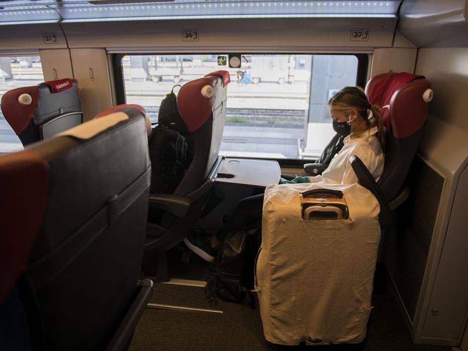 TURIN, ITALY - JUNE 3: A traveler wearing protective gear sits inside an Italo Train before departin