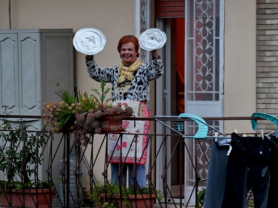 ROME, ITALY: A resident uses pot lids to play cymbals as she takes part in a flash mob called 